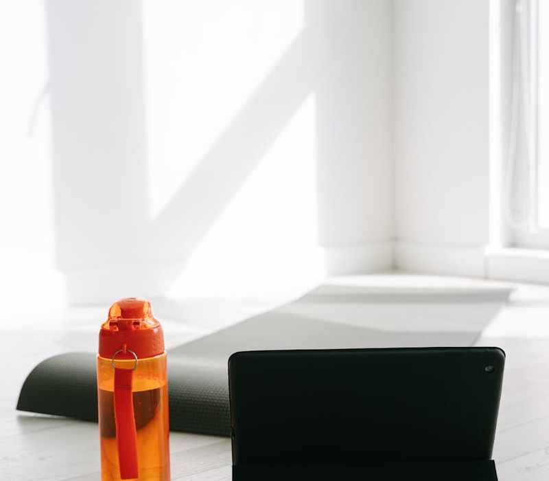 Yoga mat, water bottle, and a small towel neatly arranged on the floor.